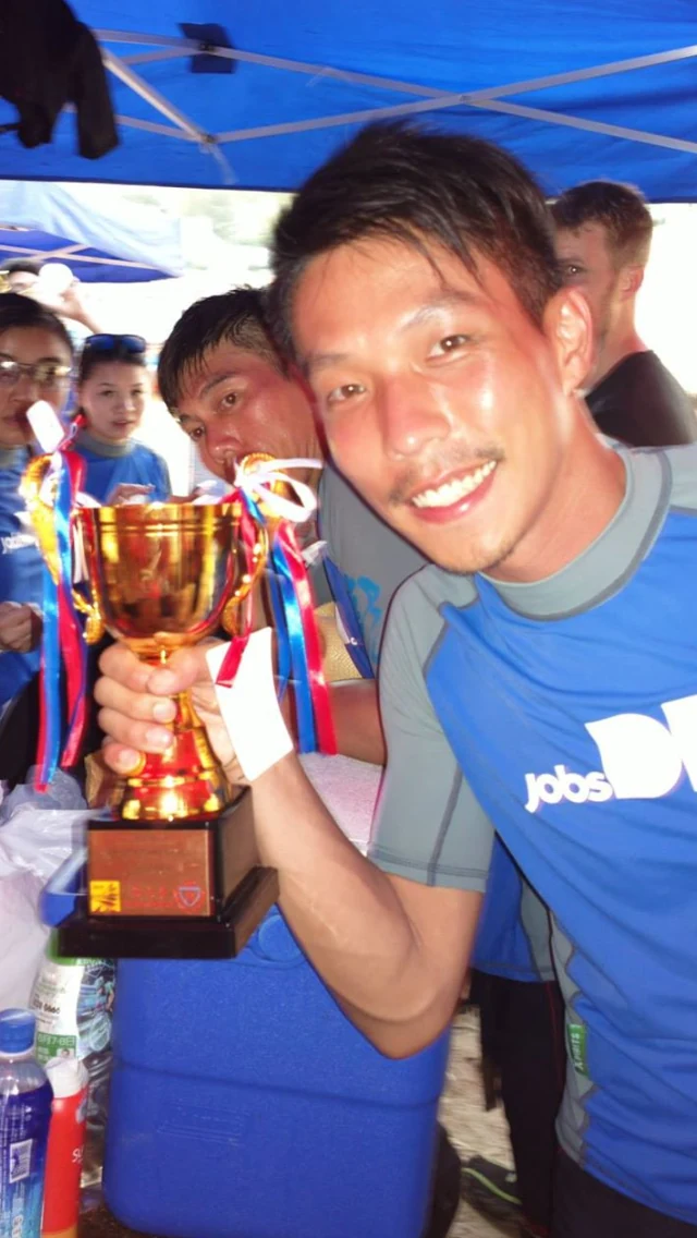 SEEK Asia team photograph at a Dragon Boat event, with a trophy in the foreground