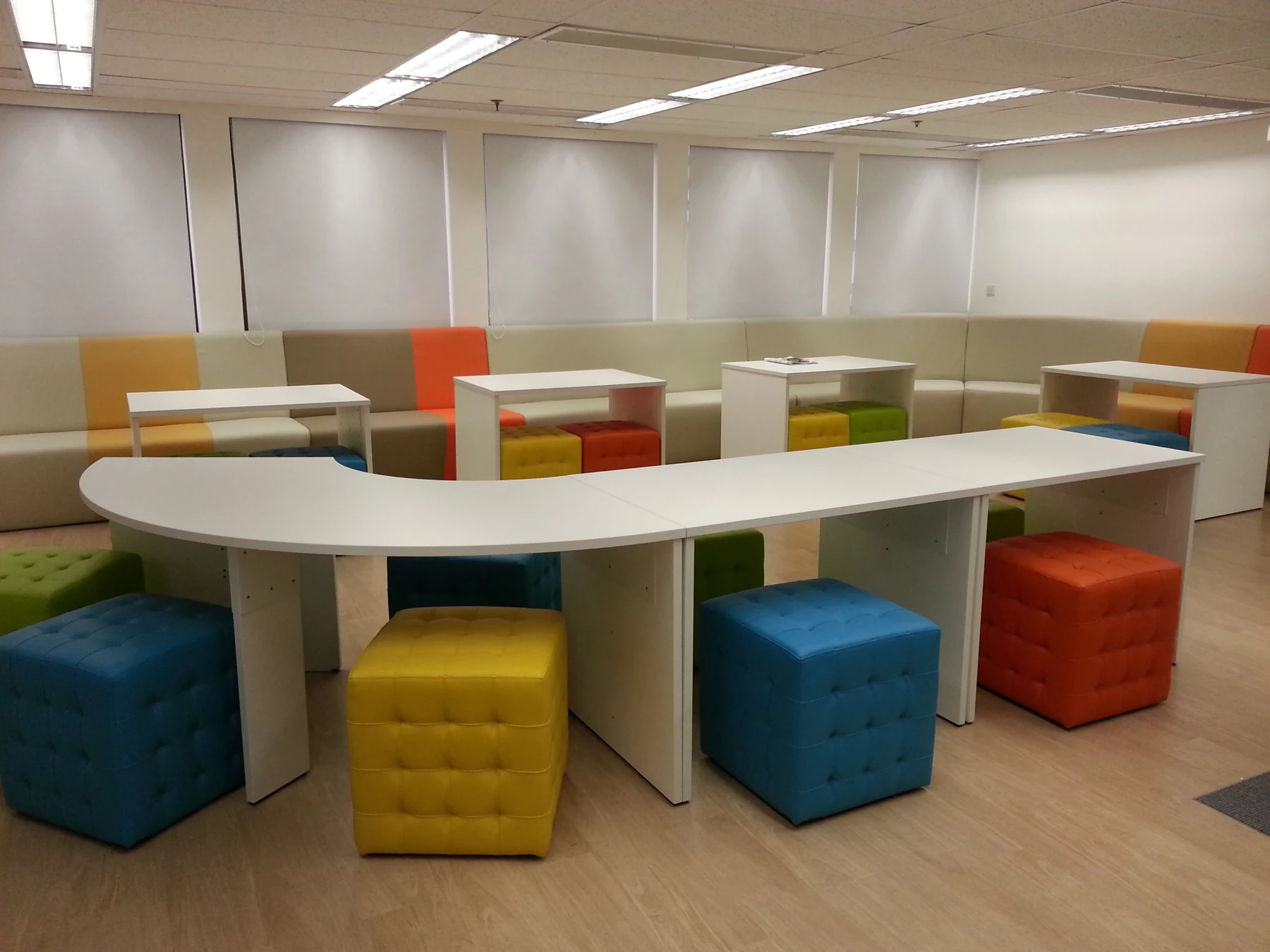 Shared office tables with colourful stools and booth seating